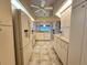 Bright kitchen with white appliances and tile floor open to the dining area at 8157 Hidden Hills Dr, Spring Hill, FL 34606