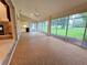 Screened lanai with ceiling fan overlooking landscaped backyard at 8157 Hidden Hills Dr, Spring Hill, FL 34606