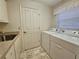 Laundry room includes sink, washer, dryer, and neutral color scheme at 8157 Hidden Hills Dr, Spring Hill, FL 34606