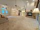 Large living room with a brick fireplace, plush seating, and a view through the double front doors at 8157 Hidden Hills Dr, Spring Hill, FL 34606