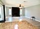 Open-concept living room featuring a stone fireplace, large windows, and wood-look flooring at 8514 Seeley Ln, Hudson, FL 34667