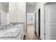 Bright bathroom featuring a double sink with granite countertop and wood-look tile flooring at 8983 Wade St, Brooksville, FL 34613