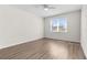 Bedroom with wood-look flooring, ceiling fan, and bright window at 8983 Wade St, Brooksville, FL 34613