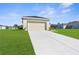 Well-maintained exterior of a home with a large driveway and lush lawn at 8983 Wade St, Brooksville, FL 34613
