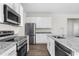 Modern kitchen with stainless steel appliances, granite countertops, and white cabinets at 8983 Wade St, Brooksville, FL 34613