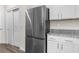 Modern kitchen with stainless steel refrigerator, granite countertops, and white cabinets at 8983 Wade St, Brooksville, FL 34613