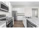 Modern kitchen with stainless steel appliances, granite countertops, and white cabinetry at 8983 Wade St, Brooksville, FL 34613