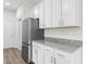 Modern kitchen with stainless steel refrigerator, granite countertops, and white cabinets at 8983 Wade St, Brooksville, FL 34613