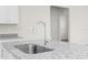 Close-up of the kitchen sink, granite countertops, and white cabinets at 8983 Wade St, Brooksville, FL 34613