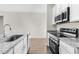 Modern kitchen with stainless steel appliances, granite countertops, and white cabinetry at 8983 Wade St, Brooksville, FL 34613