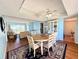 Open-concept dining area featuring a round table, ceiling fan, and seamless transition to the living room at 9000 Commodore Dr # 302, Seminole, FL 33776