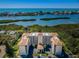 Waterfront condo complex with stunning water views, tropical landscaping, and covered parking at 9000 Commodore Dr # 302, Seminole, FL 33776