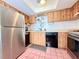 Functional kitchen with stainless steel refrigerator, laminate countertops, and wood cabinets at 9000 Commodore Dr # 302, Seminole, FL 33776