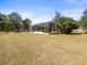Expansive backyard with lawn, leading to the screened lanai at 10188 Whisper Ridge Trail Trl, Weeki Wachee, FL 34613