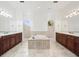 Large bathroom with dual vanities, a central bathtub, and white tile flooring at 10188 Whisper Ridge Trail Trl, Weeki Wachee, FL 34613