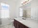 Bathroom featuring elegant vanity with quartz countertop, modern fixtures, and tiled shower at 10188 Whisper Ridge Trail Trl, Weeki Wachee, FL 34613