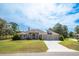 Charming exterior of the house with a well-manicured lawn and a three-car garage at 10188 Whisper Ridge Trail Trl, Weeki Wachee, FL 34613