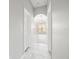 Hallway view leading into a light-filled room, featuring tiled floors and neutral colors at 10188 Whisper Ridge Trail Trl, Weeki Wachee, FL 34613
