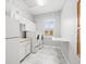 Bright laundry room with front loading washer and dryer, white cabinets, and folding table at 10188 Whisper Ridge Trail Trl, Weeki Wachee, FL 34613