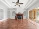 Cozy living room featuring hardwood floors, a fireplace, and a ceiling fan at 10188 Whisper Ridge Trail Trl, Weeki Wachee, FL 34613
