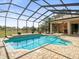 Screened-in pool with brick surround, view of the lanai and backyard at 10188 Whisper Ridge Trail Trl, Weeki Wachee, FL 34613