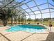 Screened-in pool with brick surround and views of the green backyard and surrounding neighborhood at 10188 Whisper Ridge Trail Trl, Weeki Wachee, FL 34613