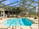 Sparkling pool with screen enclosure surrounded by trees at 10188 Whisper Ridge Trail Trl, Weeki Wachee, FL 34613