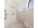 Walk-in shower featuring neutral tiles, a built-in bench, and arched windows at 10188 Whisper Ridge Trail Trl, Weeki Wachee, FL 34613