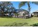 Spacious backyard with lush green lawn and a well-maintained raised garden bed leading to a screened-in pool at 11700 Leda Ln, New Port Richey, FL 34654