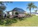 Grassy backyard with landscaped terrace and screened in lanai/pool for relaxation and entertaining outdoors at 11700 Leda Ln, New Port Richey, FL 34654