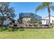 Expansive backyard featuring a lush lawn, raised garden bed, and screened-in pool area, perfect for outdoor enjoyment at 11700 Leda Ln, New Port Richey, FL 34654