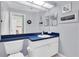 Neutral bathroom with a navy blue vanity and mirror along with maritime decor at 11700 Leda Ln, New Port Richey, FL 34654