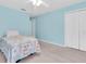 Cozy bedroom featuring calming blue walls, closet, carpet and a ceiling fan at 11700 Leda Ln, New Port Richey, FL 34654