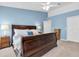 Main bedroom featuring a dark sleigh bed, blue walls and carpet at 11700 Leda Ln, New Port Richey, FL 34654