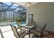 Covered patio with a glass table and chairs that overlook the pool at 11700 Leda Ln, New Port Richey, FL 34654