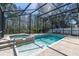 Enclosed swimming pool and spa with a screened enclosure, surrounded by trees at 11700 Leda Ln, New Port Richey, FL 34654