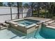 Outdoor spa with integrated steps and tile-trim surrounded by the pool at 11700 Leda Ln, New Port Richey, FL 34654