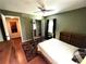 Cozy bedroom with hardwood floors, ceiling fan, natural light, and closet with ample storage space at 12027 Hoosier Ct # 104, Hudson, FL 34667