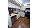 Well-lit kitchen featuring white cabinetry, stainless steel appliances, and wood-look flooring at 12027 Hoosier Ct # 104, Hudson, FL 34667