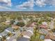 An aerial view of a neighborhood with a lake and surrounding lush greenery and trees at 13032 Pinnacle Ln, Hudson, FL 34669