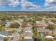 An aerial view of a neighborhood near a green golf course and wooded area at 13032 Pinnacle Ln, Hudson, FL 34669