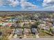 An aerial view of the neighborhood showcasing residential homes, lawns, a golf course, and a peaceful lake at 13032 Pinnacle Ln, Hudson, FL 34669