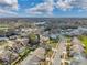 An aerial view of the neighborhood showcasing residential homes, lawns, landscaping, and a peaceful lake at 13032 Pinnacle Ln, Hudson, FL 34669