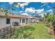View of the fenced backyard featuring lush green grass and an enclosed porch for outdoor entertaining at 13032 Pinnacle Ln, Hudson, FL 34669