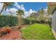 Landscaped backyard featuring lush green grass, trees, shrubs, and decorative mulch at 13032 Pinnacle Ln, Hudson, FL 34669