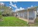 Home's backyard featuring a cozy sunroom, patio space, and grassy lawn providing a versatile outdoor living experience at 13032 Pinnacle Ln, Hudson, FL 34669