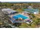 Aerial view of a sparkling pool surrounded by lounge chairs, palm trees, and lush landscaping at 13032 Pinnacle Ln, Hudson, FL 34669