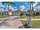 Lovely home featuring mature palm trees, green lawn, and a neatly maintained front yard at 13032 Pinnacle Ln, Hudson, FL 34669