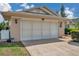 Close-up of a home's garage featuring exterior lighting and landscaping at 13032 Pinnacle Ln, Hudson, FL 34669