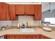 Close-up of the kitchen sink, features wood cabinets with a gray countertop and a white sink at 13032 Pinnacle Ln, Hudson, FL 34669